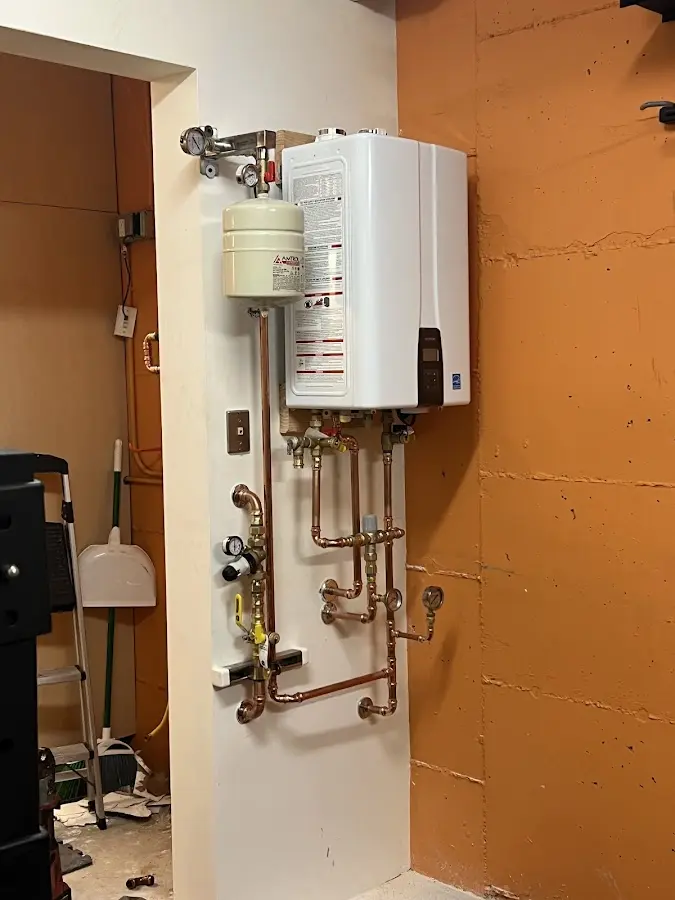 Plumbing technician inspecting water heater connections in Lakewood